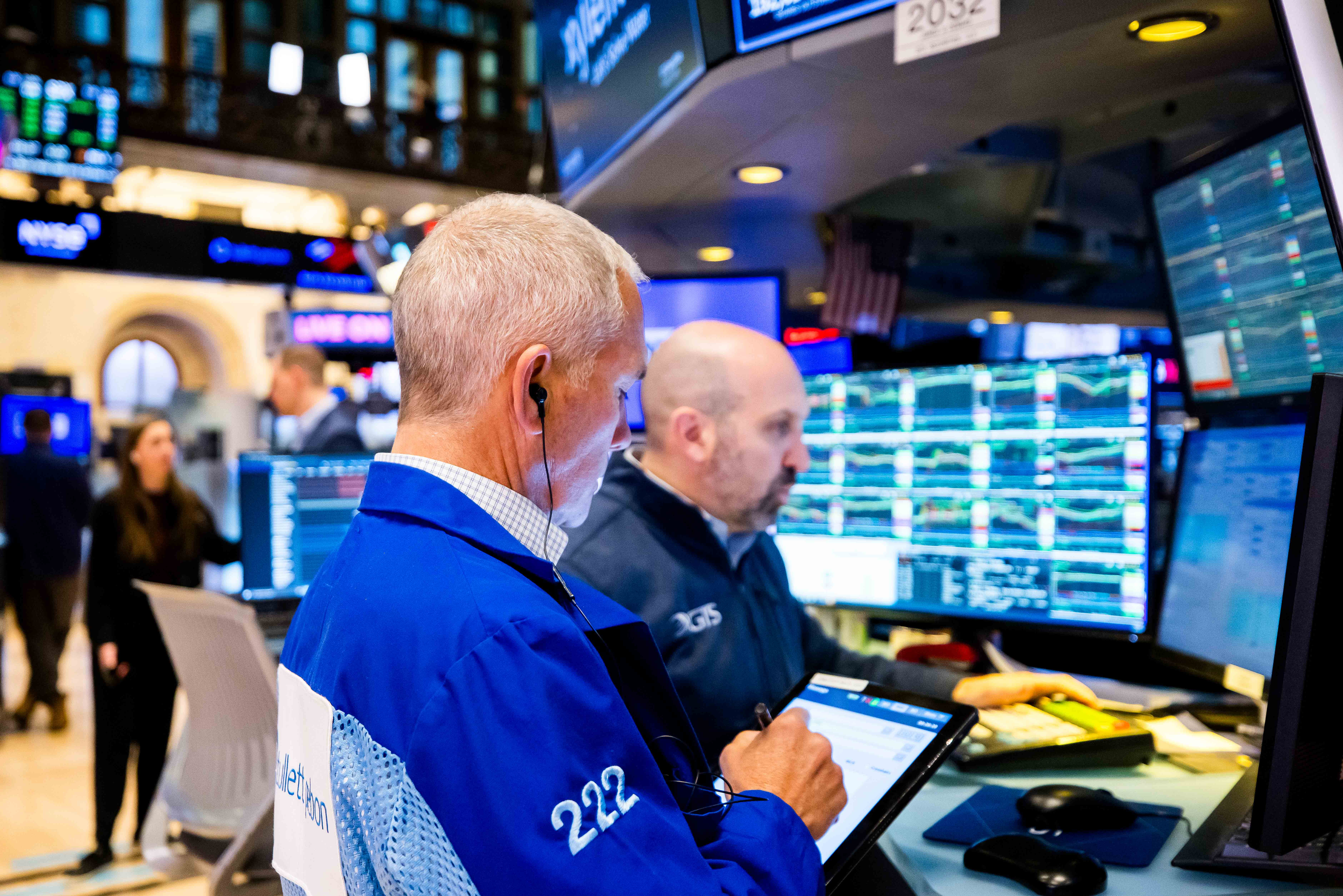 Stock market data displayed on multiple computer screens.