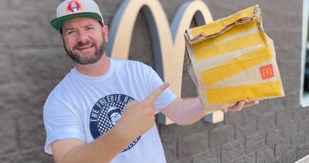 Man holding a McDonald's bag and drink