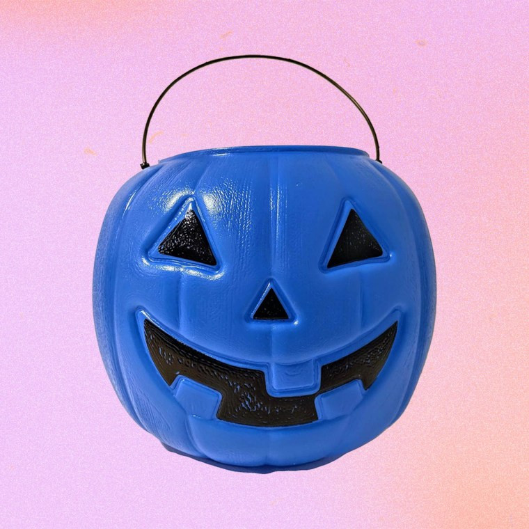 Child carrying a blue pumpkin bucket