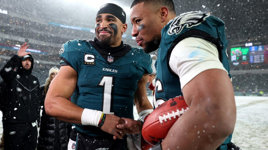 Jalen Hurts and Saquon Barkley celebrating a victory